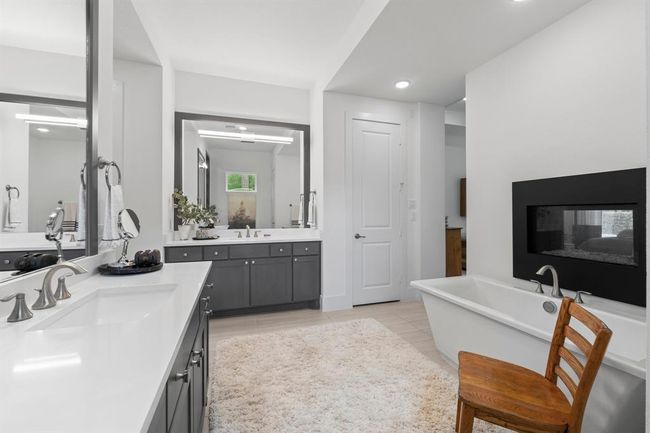 A zen inspired space with soaking tub and electric fireplace. | Image 31