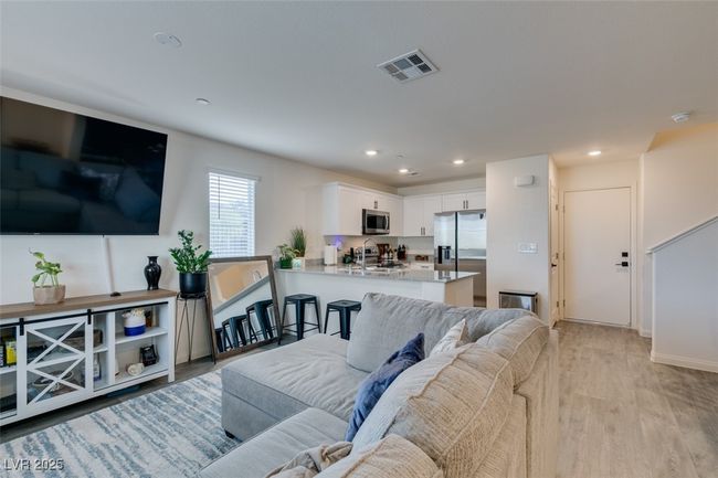 Living area featuring visible vents, baseboards, light wood finished floors, and recessed lighting | Image 11