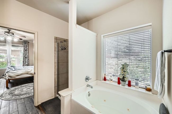 Full bath featuring a jetted tub, ceiling fan, and wood finished floors | Image 21