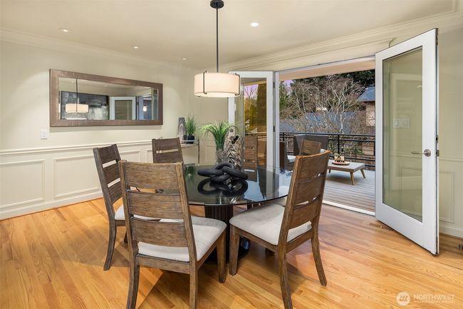 Classical wainscotting adorn this fabulous dining room. Bring the outdoors in! French doors open up to the outdoor balcony for an easy flow. | Image 7