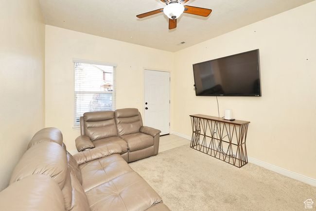 Carpeted living room featuring baseboards and a ceiling fan | Image 8