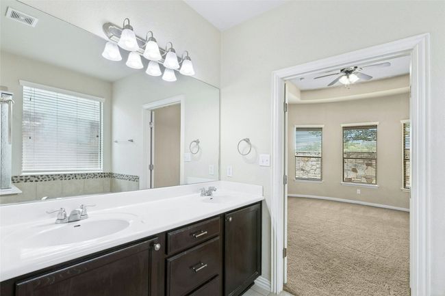 Full bath with double vanity, ceiling fan, and baseboards | Image 26