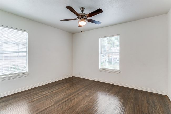 Empty room with dark wood-style floors, a ceiling fan, and a textured ceiling | Image 16