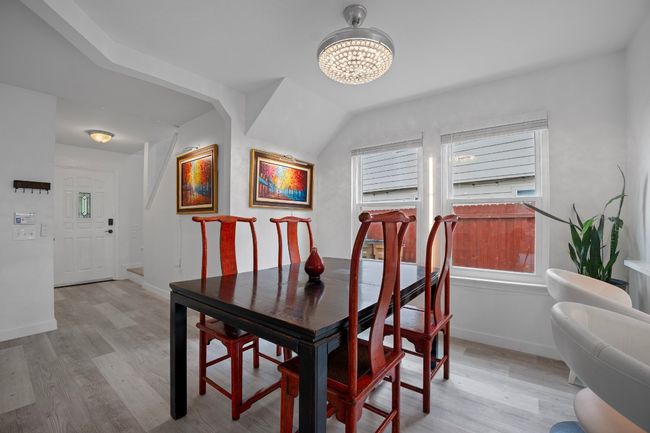 Dining area with light wood finished floors and a chandelier | Image 13