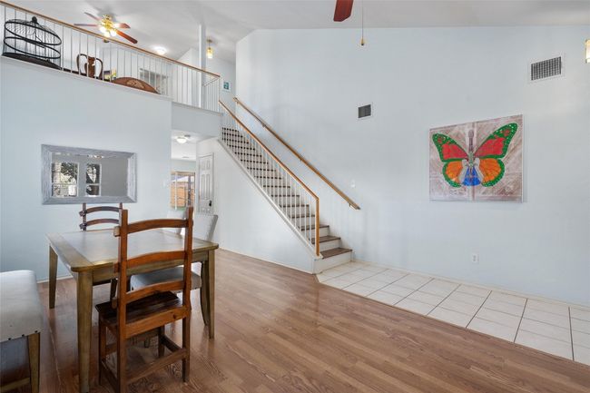 Dining room featuring stairway, ceiling fan, visible vents, and wood finished floors | Image 5