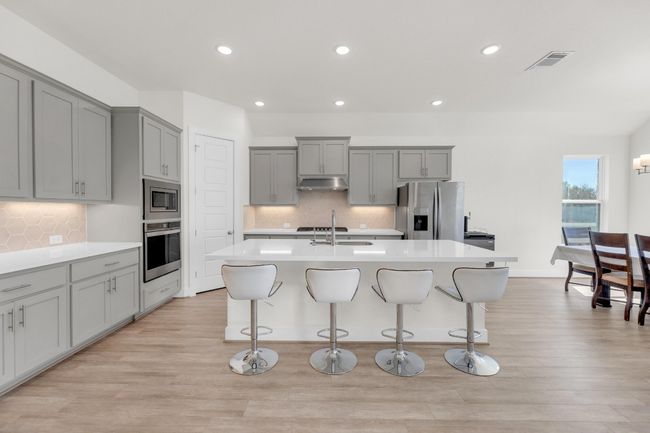 Kitchen featuring a sink, stainless steel appliances, gray cabinets, and under cabinet range hood | Image 10