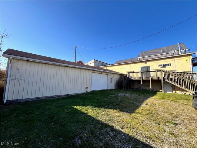 View of yard with a wooden deck, an outbuilding, stairs, and a garage | Image 4