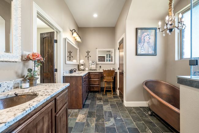 Bathroom with two vanities, a freestanding tub, stone tile floors, and recessed lighting | Image 20