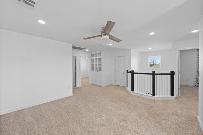 Unfurnished room featuring a ceiling fan, carpet, attic access, and visible vents | Image 22