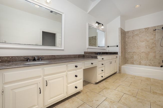 Bathroom featuring bathing tub / shower combination, double vanity, visible vents, and a sink | Image 13