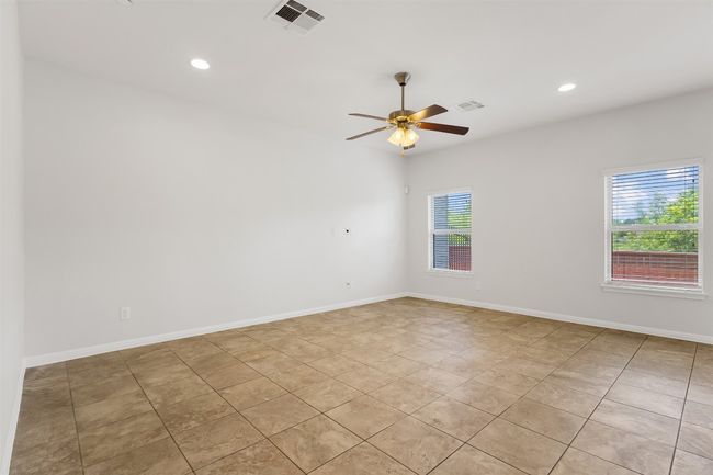 Empty room with ceiling fan, light tile patterned flooring, and recessed lighting | Image 7