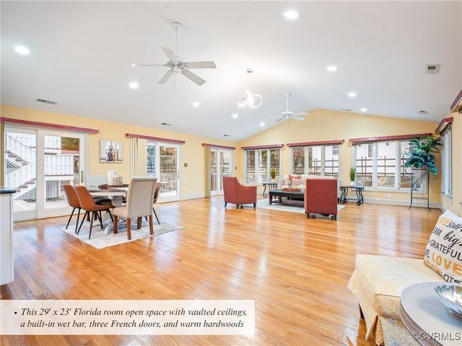 This 29' x 23' Florida room open space with vaulted ceilings, a built-in wet bar, three French doors, and warm hardwoods | Image 19