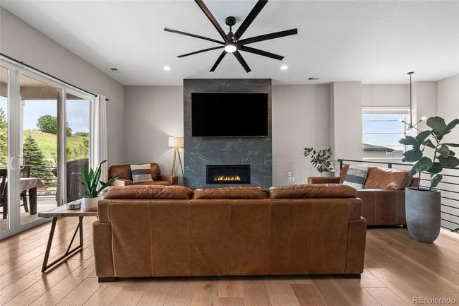 Floor to ceiling tiled fireplace, upgraded ceiling fan, white oak engineered hardwood floors - 12' sliding glass doors to outdoor patio/dining area | Image 10