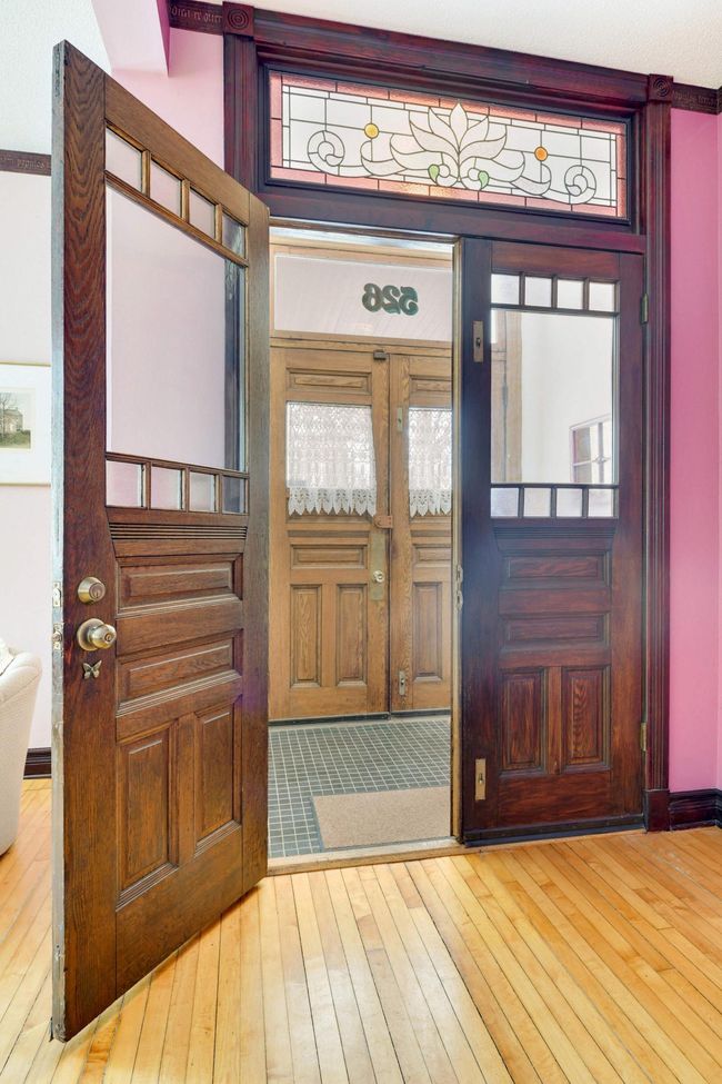 This unit has many little luxuries -- for example, the solid wood double-entry doors with period details and custom stained glass transom windows. | Image 5