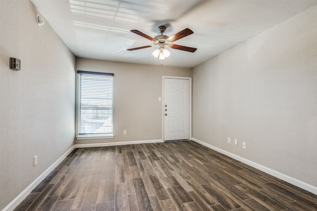 Empty room featuring a ceiling fan, dark wood-style floors, and baseboards | Image 10