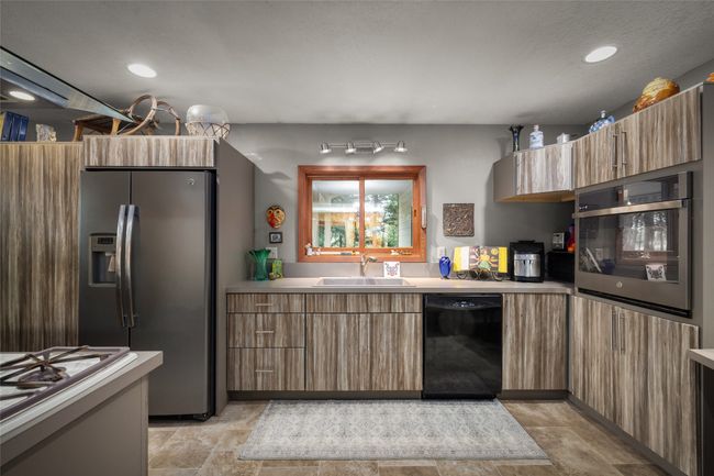 Kitchen with appliances with stainless steel finishes, a sink, light countertops, recessed lighting, and modern cabinets | Image 23