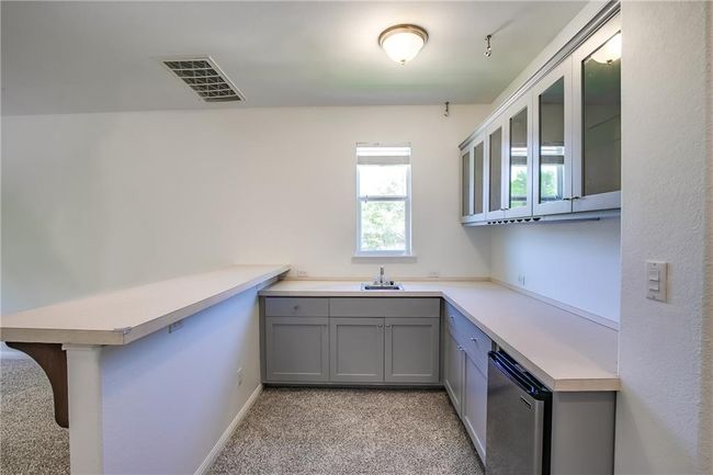 Kitchen with gray cabinets, light colored carpet, and light countertops | Image 23