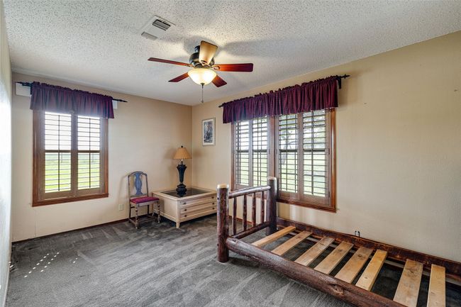 Bedroom featuring carpet floors, a textured ceiling, and ceiling fan | Image 12