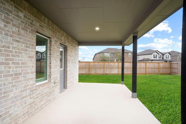 Enjoy relaxing evenings under the spacious covered patio, perfect for outdoor dining, morning coffee, or simply taking in the peaceful backyard views. | Image 35