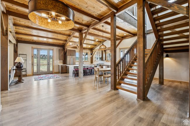 Stairs featuring baseboards, wood finished floors, vaulted ceiling with beams, and wood ceiling | Image 31