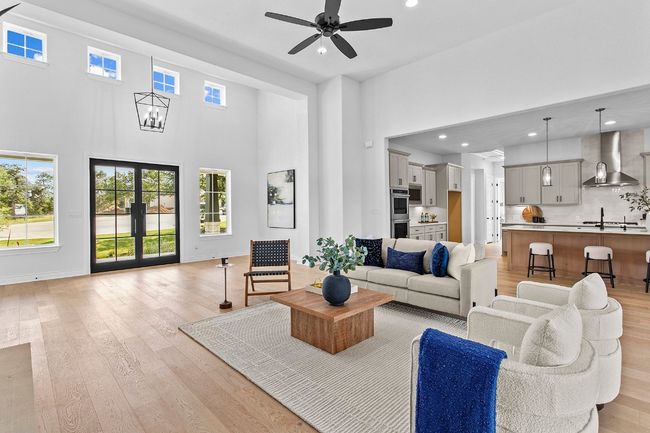 Living area with a high ceiling, recessed lighting, healthy amount of natural light, light wood-style floors, and ceiling fan | Image 6