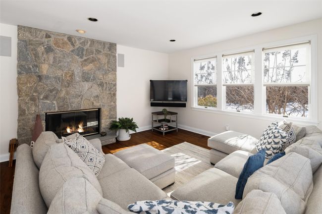 Light and bright great room/ family room dark hardwood-floors, stone wood burning fireplace, and recessed lighting | Image 15