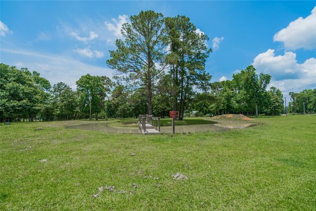 I loved this feature of the property. A pond built completely around a group of trees, and a really neat bridge going to the island. The pond is stocked with great fish and is 4' deep on one side, and 8' deep on the other. Your family and friends will have some Great Memories here. | Image 33