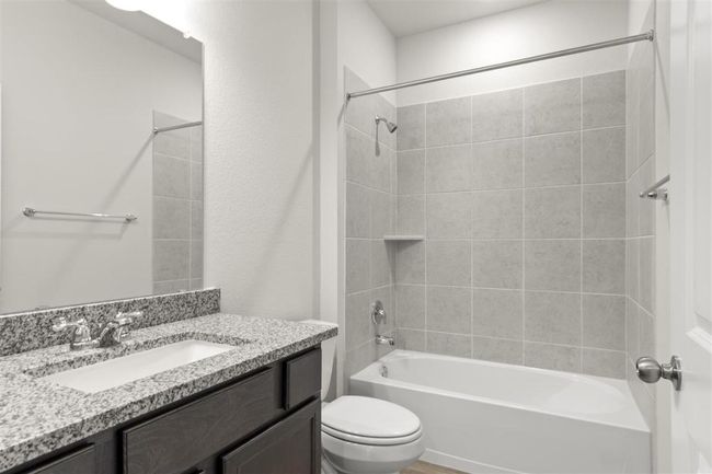 Bathroom featuring toilet, bathtub / shower combination, and vanity | Image 25