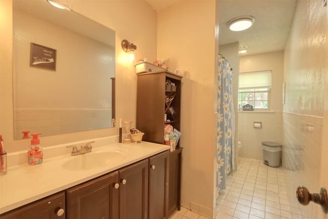 Full bathroom with tile patterned flooring, vanity, and curtained shower | Image 28