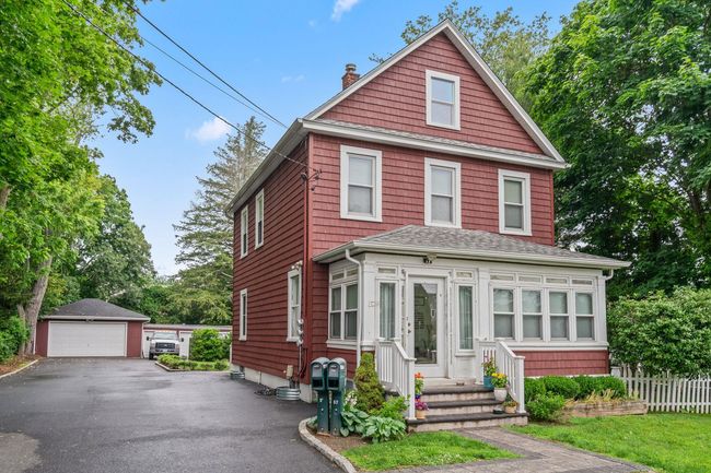 American foursquare style home with a chimney, a detached garage, an outdoor structure, and roof with shingles | Image 6