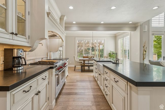 Kitchen featuring double oven range, dark countertops, light wood-style flooring, recessed lighting, and decorative backsplash | Image 15