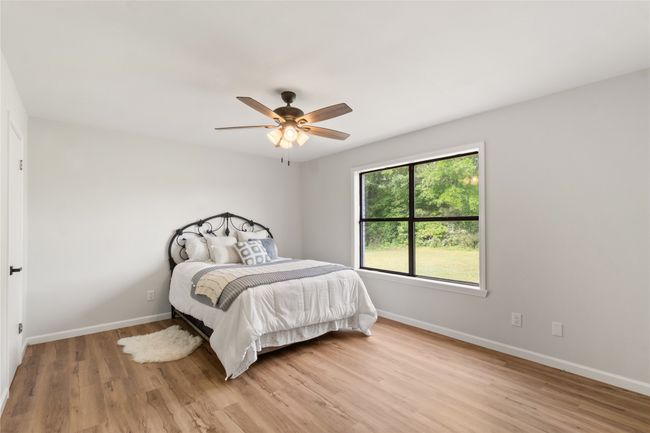 Bedroom with light wood-style floors and ceiling fan | Image 21