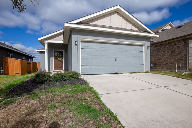 Ranch-style house with a garage, board and batten siding, and driveway | Image 6