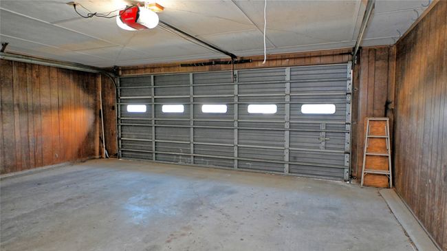Garage with a garage door opener and wood walls | Image 17