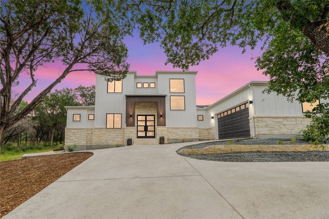 Contemporary house featuring stone siding, driveway, a garage, and board and batten siding | Image 39