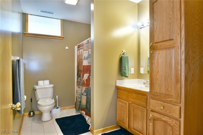Bathroom featuring toilet, tile patterned flooring, vanity, baseboards, and a shower with curtain | Image 42