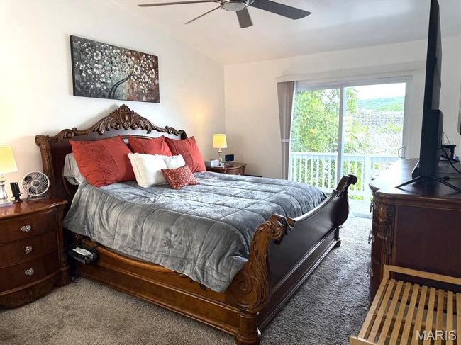 Carpeted bedroom featuring access to exterior, vaulted ceiling, and a ceiling fan | Image 25