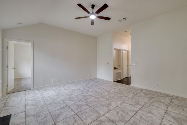 Unfurnished bedroom featuring vaulted ceiling and ceiling fan | Image 7
