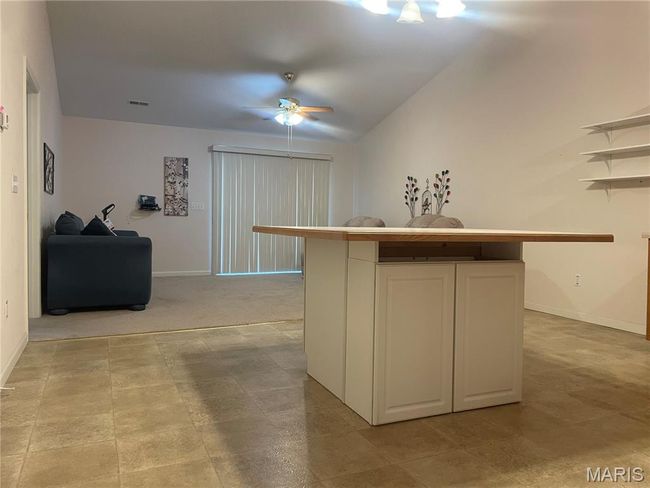 Kitchen with baseboards, white cabinets, and a ceiling fan | Image 8