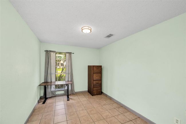 Cozy second bedroom with natural light, perfect for a guest room or home office. | Image 25