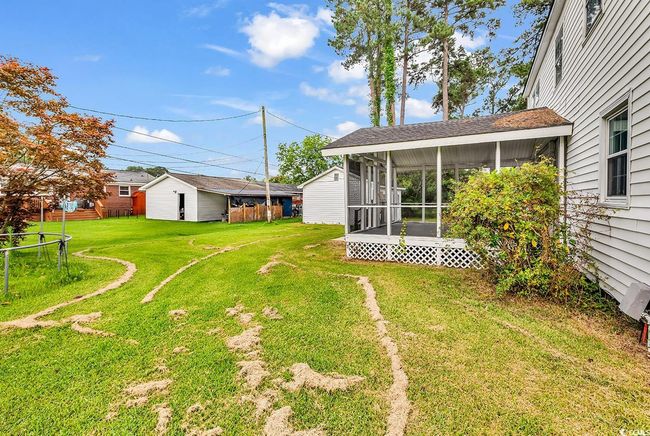View of grassy yard with a sunroom and an outdoor structure | Image 30