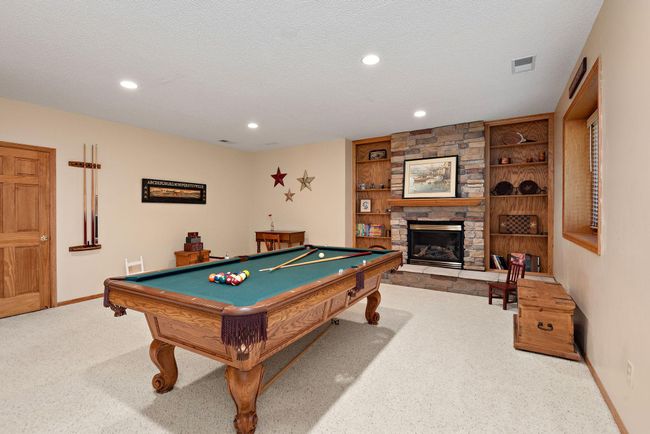 Lower level amusement room with gas fireplace and built-in cabinets. | Image 25