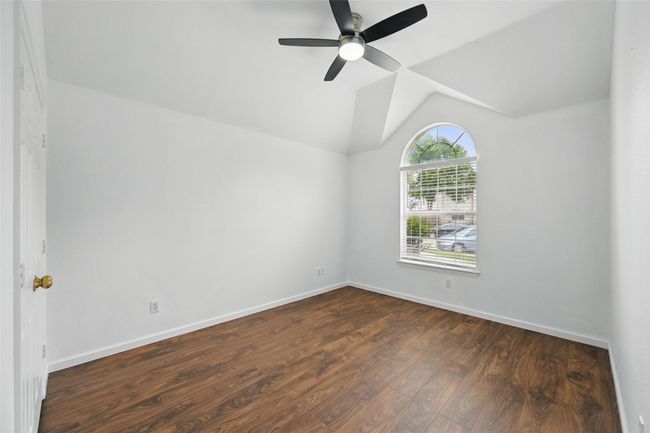 Empty room featuring dark wood-style flooring, ceiling fan, vaulted ceiling, and baseboards | Image 10