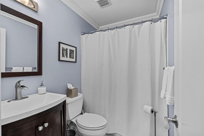 Bathroom featuring toilet, visible vents, a shower with shower curtain, vanity, and ornamental molding | Image 16