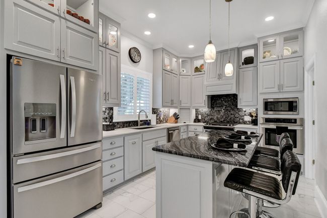 Kitchen featuring stainless steel appliances, light marble finish flooring, crown molding, recessed lighting, and a kitchen island | Image 12