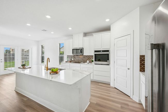 Kitchen with a large center island with plenty of natural light. | Image 4