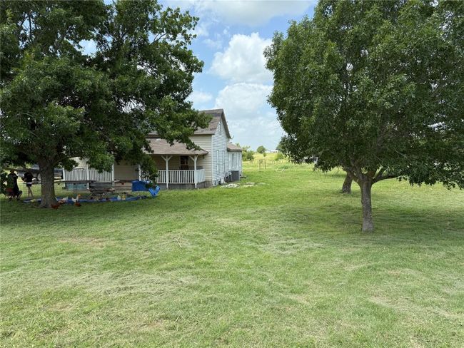 View of grassy yard with covered porch and central AC | Image 14