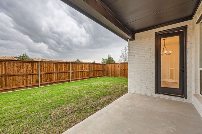 View of yard featuring a fenced backyard and a patio area | Image 26