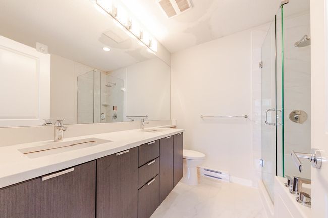 Full bathroom with a baseboard radiator, a stall shower, double vanity, and recessed lighting | Image 19