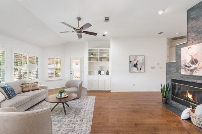 Living room with wall of windows and cozy fireplace. | Image 6